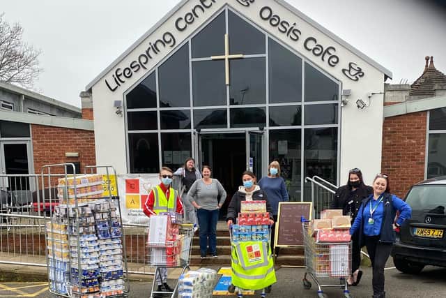 Staff from Heron Foods present members of Lifespring Church with the donations from kind-hearted shoppers.