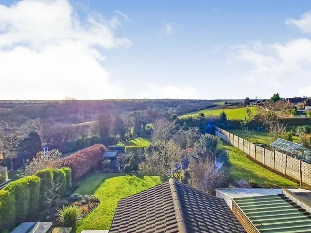This image, taken from one of the upper-floor bedrooms, shows the superb countryside views overlooking the rear garden and the fields beyond.