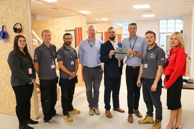 City & Guild's Johnathan Price 4th right presents apprenticehip manager Paul Stringer with the plaque