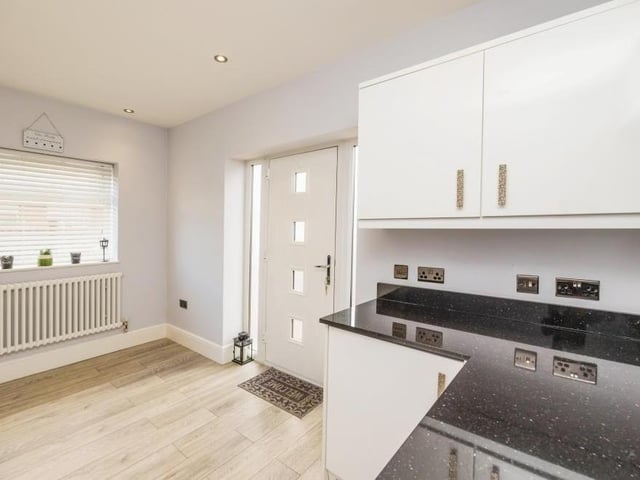 Just off the kitchen is this useful utility room, with storage and worktops. The door leads out to the side of the property.