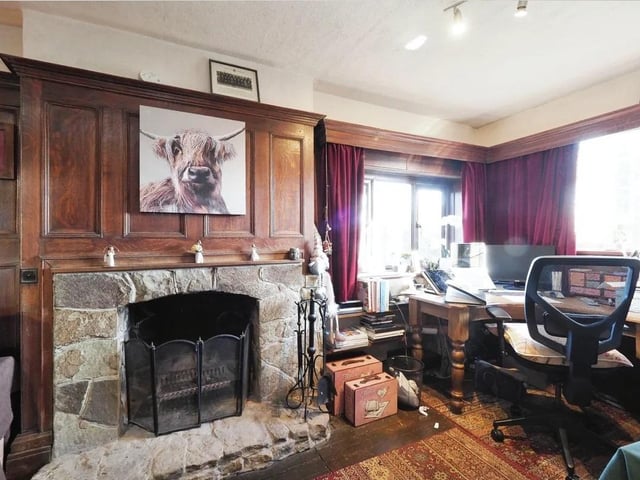 The study/home office has wooded panelling, wood flooring, dual aspect and a working open log fire.