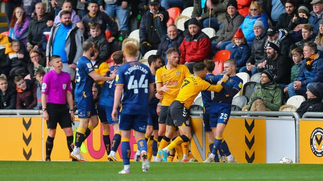 Newport County midfielder Robbie Willmott pushes Mansfield Town midfielder Ryan Stirk before John-Joe O'Toole is set off in the melee.