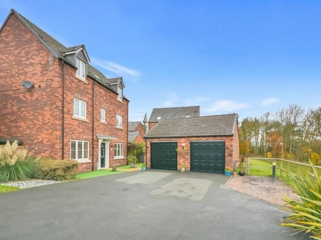 As we step outside, let's take a look at the detached, twin-door double garage at the front of the property. It is fitted with external LED downlighting and, internally, there is an array of power points and lighting.