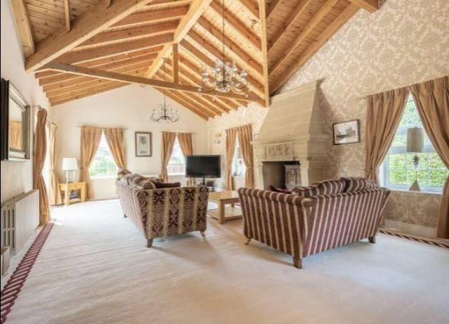 The lounge has large windows to let in an abundance of natural light, it is spacious and designed with a modern timber effect.