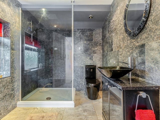 The en suite shower room to the master bedroom has the wow factor, especially with its underfloor heating. A modern, attractive three-piece suite comprises a walk-in shower enclosure, vanity unit with inset wash hand basin and storage cupboard beneath, and a low-flush WC. The walls and floor are tiled, while four ceiling spotlights and a chrome. heated towel-rail inject even more style.
