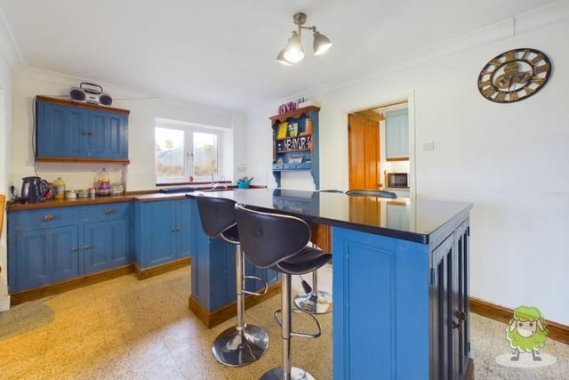 The first room to take a look at is the colourful breakfast kitchen, which is fitted with a range of units and a central island. Just off is a separate utility room.