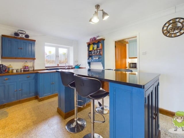 The first room to take a look at is the colourful breakfast kitchen, which is fitted with a range of units and a central island. Just off is a separate utility room.