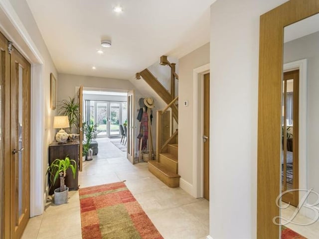 Time now to check out the first floor, so let's pass through the large and airy entrance hallway to climb the staircase to the right. The hall features an under-stairs storage cupboard, a tiled floor and inset spotlights to the ceiling, and also gives access to a downstairs cloakroom.