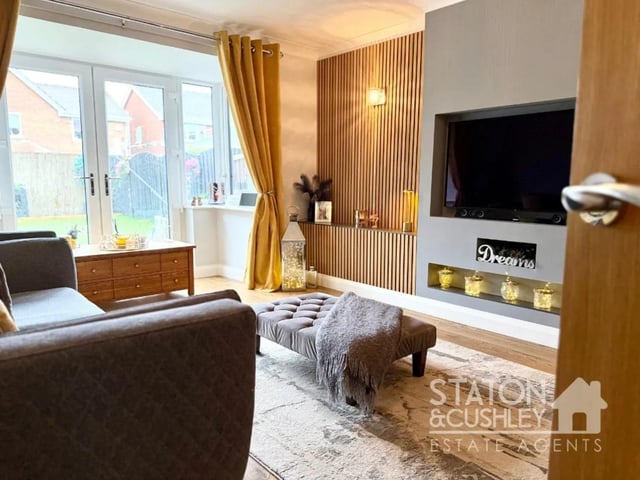 The family living room is both inviting and practical, featuring a bespoke media wall that creates a stylish focal point while maintaining a cosy atmosphere