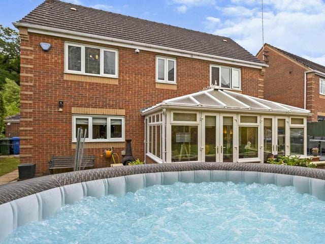 Our last photo shows the Eakring Road property from the rear. The pool is optional, but the rest of the garden is well maintained, with mature flowerbeds and storage sheds.