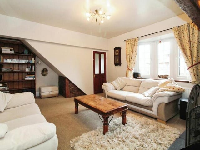 As the main reception room, the tastefully decorated living room generates a warm and inviting atmosphere. The door shown here leads to the staircase to the first floor.