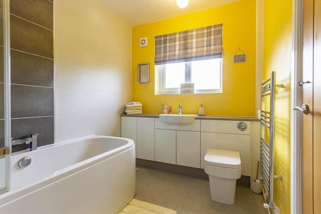 The family bathroom also sits on the ground floor and is fitted with a contemporary, white three-piece suite. It comprises a panelled bath with folding glass shower screen and mixer shower over, semi-inset wash hand basin with storage below and at the side, and a WC with concealed cistern. There's a chrome, heated towel-rail too.