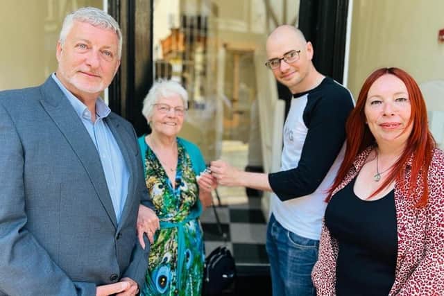 Paul Williams and Maria Jowett from Brunts Charity presented Lynn Hunt with a bouquet as she handed the keys over to new owner Richard Reynolds. Picture: Collum Sharpe/Mansfield BID