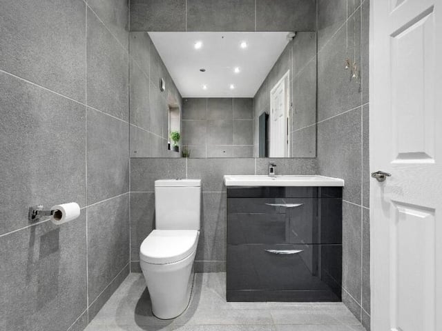 The family bathroom contains an attractive, wall-hung wash hand basin with a chrome mixer tap and fitted storage drawers.