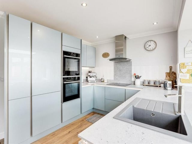 Next stop is the contemporary, refitted kitchen, which features an induction hob with extractor fan, an integrated Neff slide-and-hide oven, integrated fridge freezer and composite sink with mixer tap and drainer.