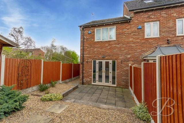 Time to go back outside now to take a look at the low-maintenance back garden. Surrounded by a fence, it offers plenty of privacy, while the French doors pictured lead into the lounge.