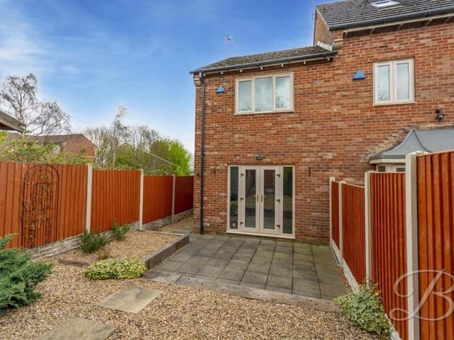 Time to go back outside now to take a look at the low-maintenance back garden. Surrounded by a fence, it offers plenty of privacy, while the French doors pictured lead into the lounge.