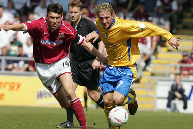 Ian Sampson of Northampton battles with Liam Lawrence of Mansfield.
