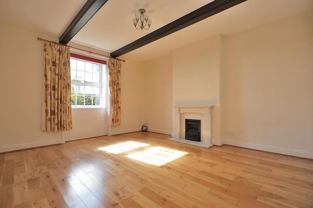 The pleasant sitting room boasts a marble fireplace with inset coal-effect gas fire, a solid wood floor and a beamed ceiling. The window faces the front of the property.