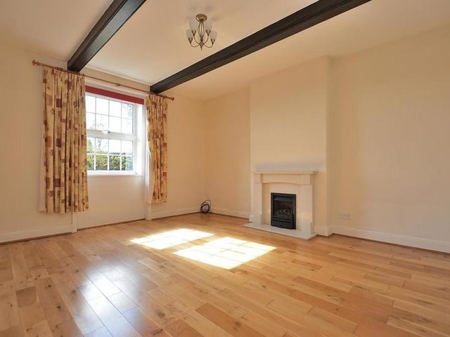 The pleasant sitting room boasts a marble fireplace with inset coal-effect gas fire, a solid wood floor and a beamed ceiling. The window faces the front of the property.
