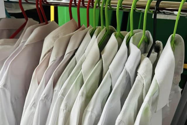 The uniform support service has a range of uniforms, including various sizes of white shirts.