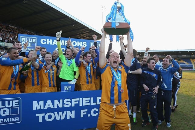 Adam Murray lifts the trophy as Mansfield celebrate winning the league.