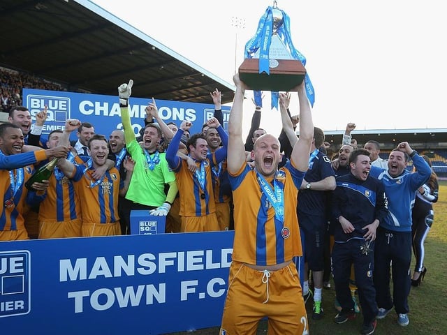 Adam Murray lifts the trophy as Mansfield celebrate winning the league.