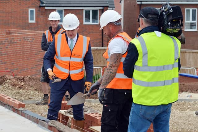 The Secretary of State for Housing Robert Jenrick MP lays a brick with help from Lee Cousins.