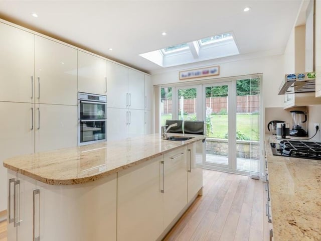 Next stop is the open-plan kitchen/dining and breakfast room, which boasts a range of modern, high-gloss cabinets comprising wall cupboards, base units and drawers, complemented by chrome handles and granite worktops.