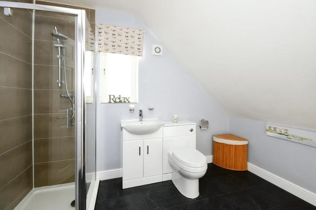 Here is the en suite to the master bedroom. It comprises a corner shower cubicle, vanity unit, wash hand basin and low-flush WC.