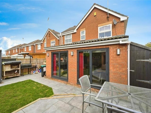 As we step outside, let's take a look at the property from the rear. In the foreground is the kitchen/diner and family room extension, with doors leading out to the garden