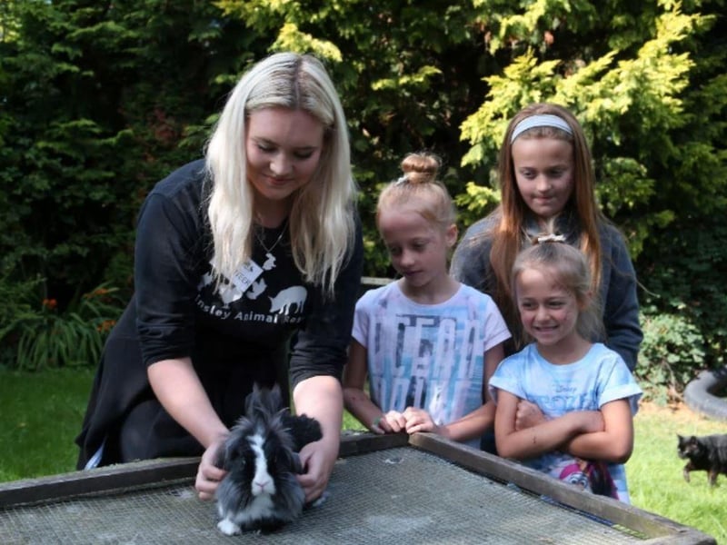 Volunteer Ellie Kohut brings out a guinea pig for visitors Ava, Scarlett and Nevaeh to meet ar Brinsley Animal Sanctuary.