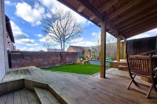 The back garden at the West Hill Avenue property features this covered seating area.