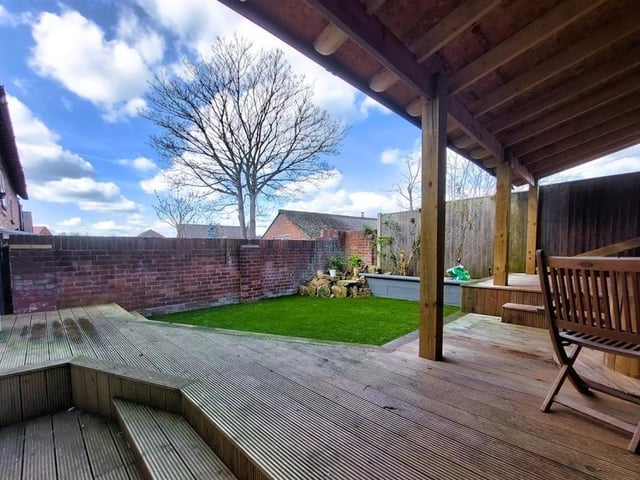 The back garden at the West Hill Avenue property features this covered seating area.