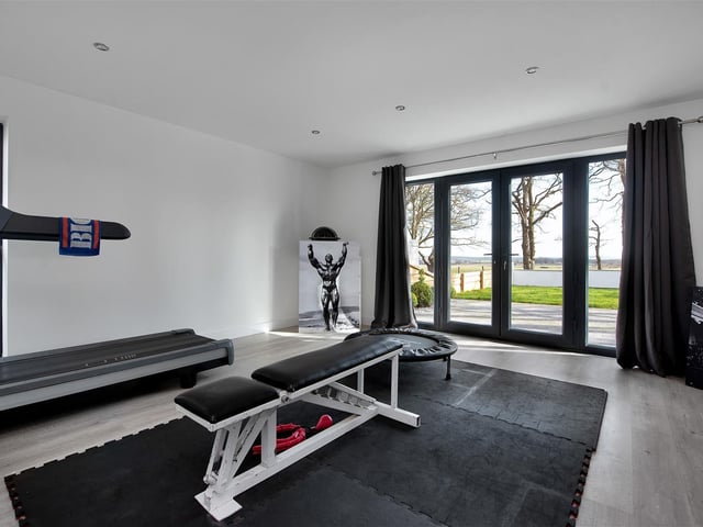 Currently utilised as a home gym, the room boasts underfloor heating and French doors leading out onto the front.