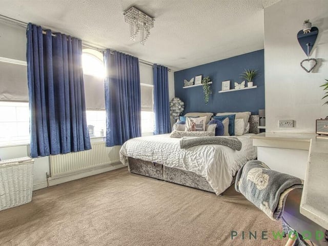 Three large, front-facing windows mean the master bedroom is a bright and light space. It also has access to an en suite bathroom.