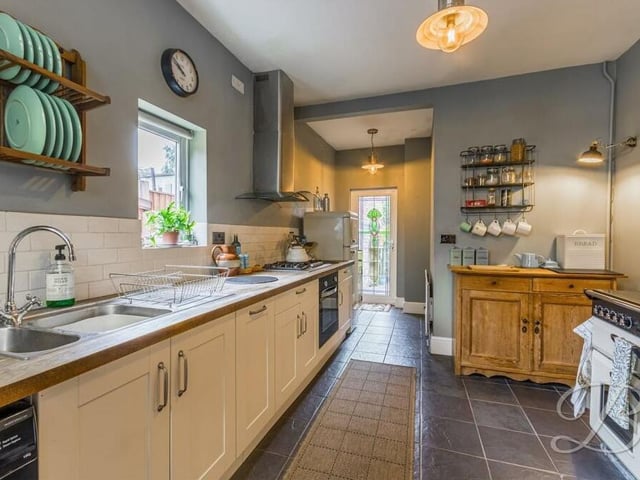 Let's step into the impressive kitchen now. It is fitted with shaker-style wall and base units, a work surface and inset sink with mixer tap above. The window overlooks the rear garden.