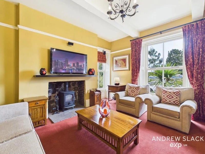 A welcoming hallway leads to a sitting room with log burner and original panelling.