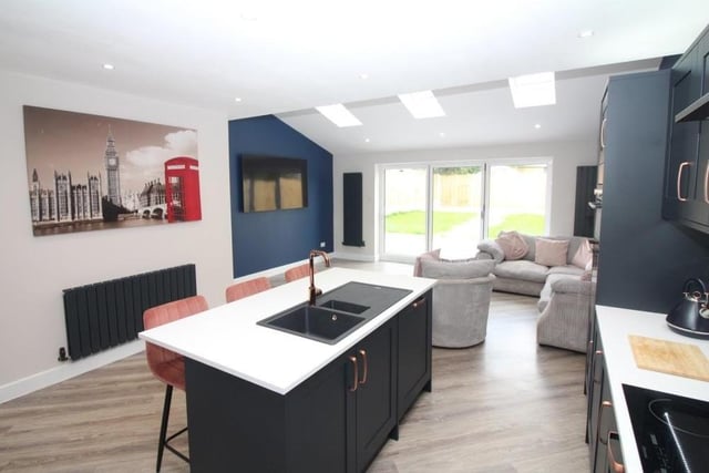 A final look at the dining kitchen and family area. A wall-mounted TV point, vertical radiators and ceiling spotlights add to its appeal, while there is also plumbing for a washing machine and combination boiler, as well as under-stairs storage space nearby.