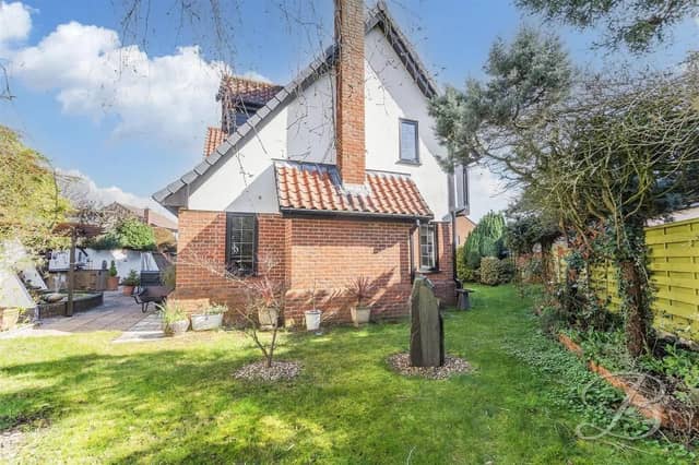 The rear garden features a well-maintained lawn and paved patio area.
