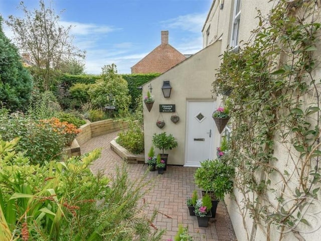 A lovely path, lined by decorative shrubbery, leads to the front door of the Kirkby house. Come on in!
