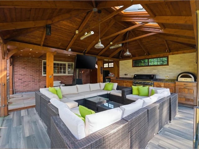 A substantial timber-framed pavilion with vaulted ceiling and skylights creates an impressive all-season setting, seamlessly blending indoor comfort with outdoor living. Fully equipped with a built-in BBQ, pizza oven and extensive preparation space, this is far more than a patio — it is a true outdoor kitchen and living area.
