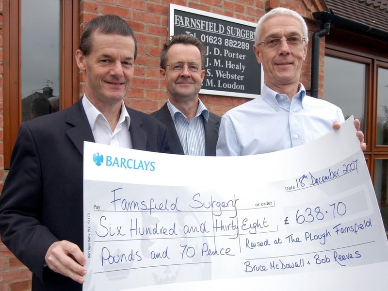 Bruce McDowall. right, presents a cheque for £636.70, the proceeds of a Beatles Quiz Night held at the Plough Inn in Farnsfield, to Drs Jim Healey and John Porter of Farnsfield Surgery.