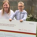 Jack Beard presenting the cheque for £120 to Clare Harris of the Emily Harris Foundation