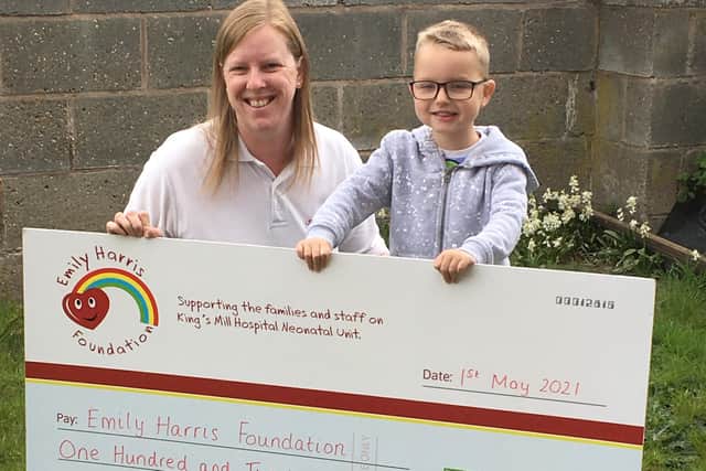 Jack Beard presenting the cheque for £120 to Clare Harris of the Emily Harris Foundation