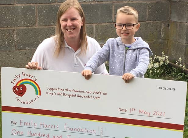Jack Beard presenting the cheque for £120 to Clare Harris of the Emily Harris Foundation