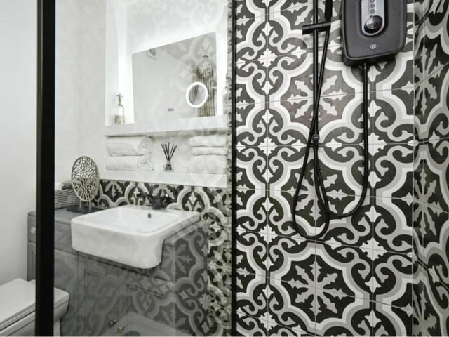 A second shot of the shower room from inside the shower enclosure. It also features a wash basin and WC.