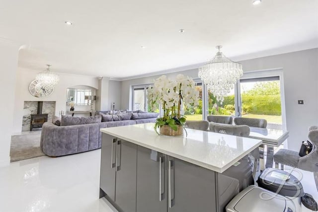 The sleek kitchen'diner, which is part of the open-plan hub at the £595,000 home, includes an island with extra cupboard space and also underfloor heating.