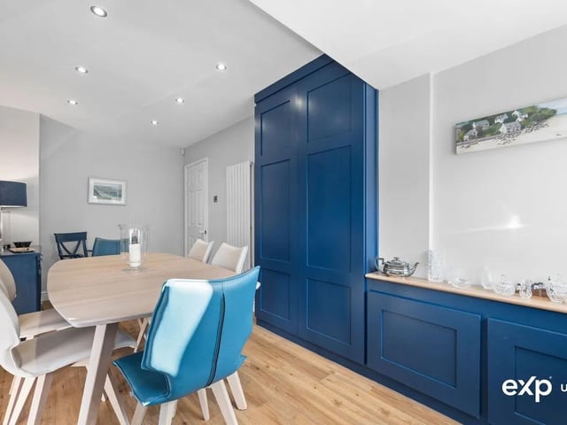 The dining room is a beautifully finished reception room with a luxurious bold décor. There is plenty of space here for a big family table. The room is decorated with wood effect flooring, and has smart streamlined fitted cupboards offering practical storage options. There is a stylish column radiator and ambient down lighting. A uPVC window overlooks the front.