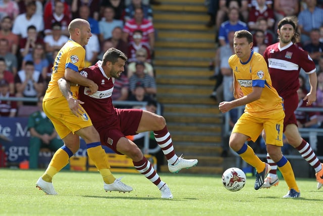 Marc Richards of Northampton Town attempts to control the ball under pressure from Adam Murray of Mansfield in 2014.